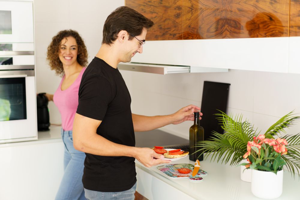 Happy couple assembling breakfast in bright kitchen