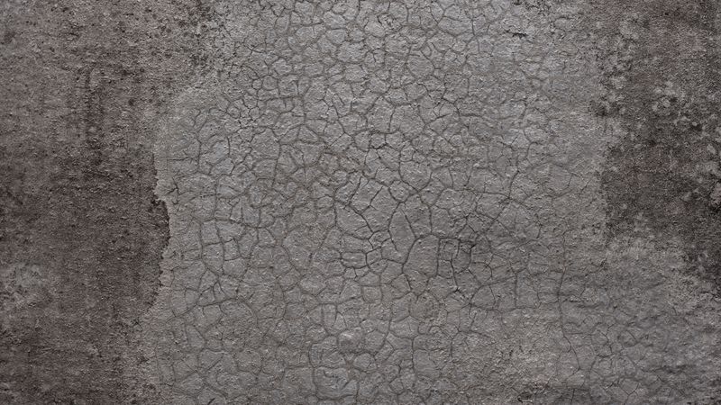 Cracked gray concrete wall with rough texture and aged surface details