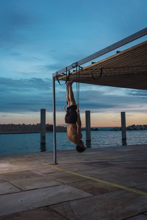 Athletic man balancing on gymnastic rings