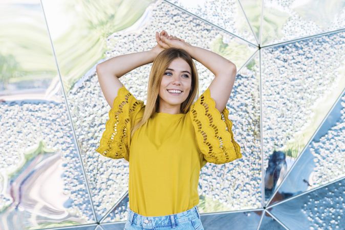 Young cheerful woman posing with hand in air