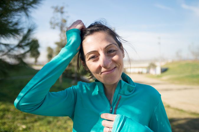 Smiling fit woman in blue shirt in park