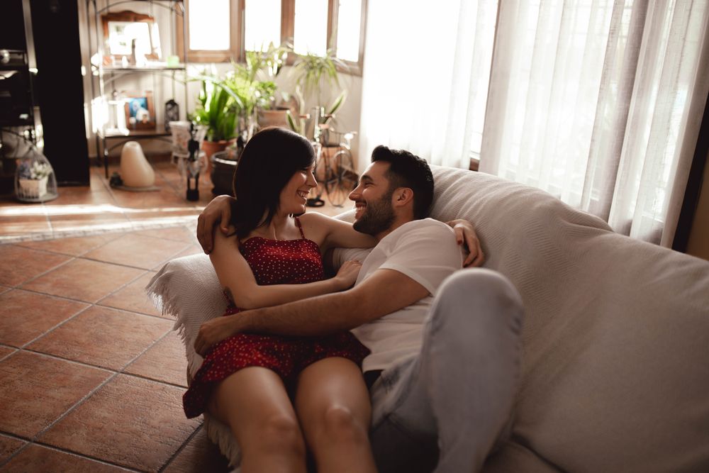 Cheerful couple hugging on sofa
