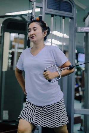 A woman uses an exercise machine at a gym