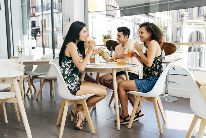 Diverse friends with smoothies sitting in cafe