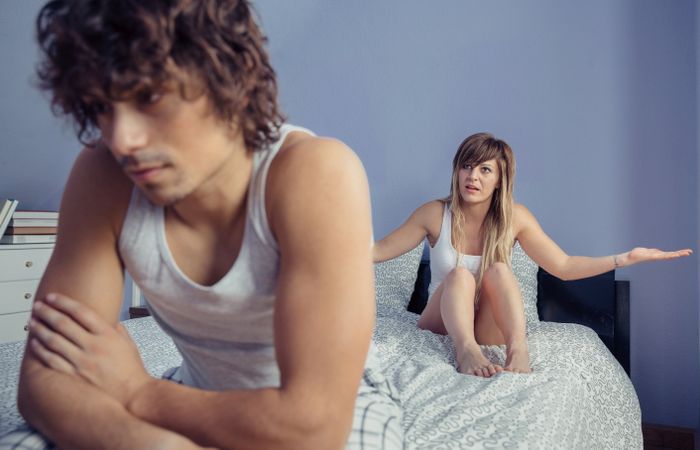 Woman over bed having quarrel with man on bed