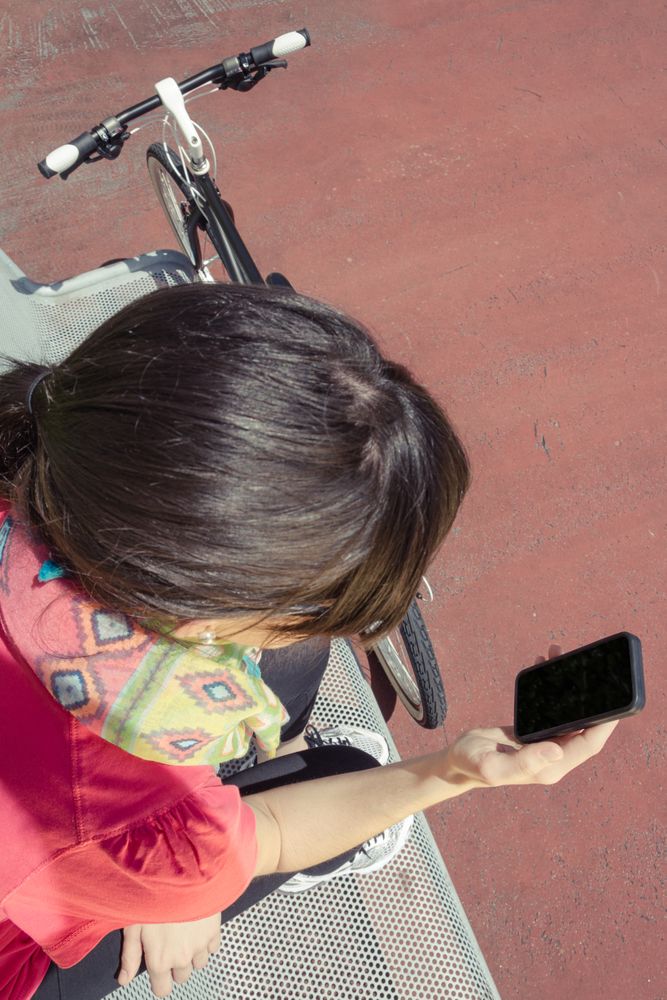 Sportive woman with fixie bike looking smartphone