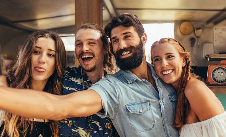 Happy young guy with friends taking a selfie