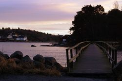Scenic town on seaside in twilight with wooden bridge