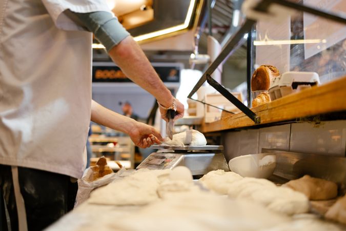 Close-up of unrecognizable man weighing dough on a scale