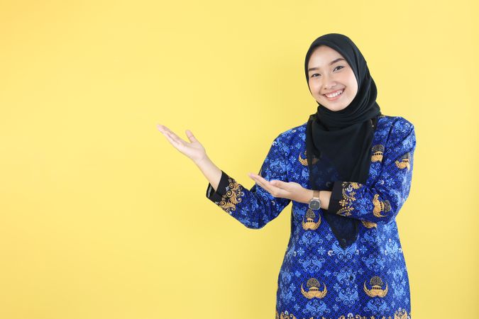 Happy Excited Cheerful Hijab Indonesian Woman Pointing on the Right Side