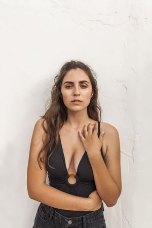 Female leaning on white wall