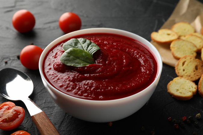 Bowl of tomato soup with crackers and spoon