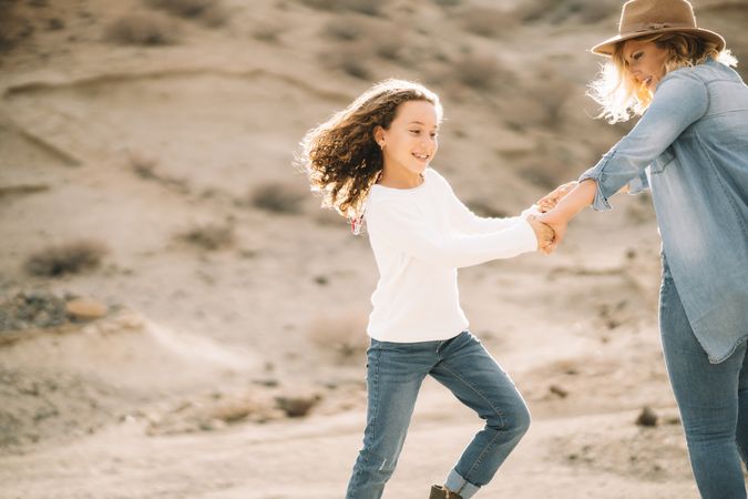Mother dancing with girl on nature