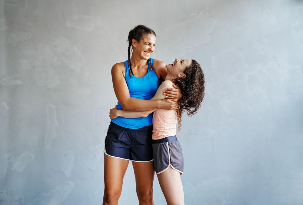 Two woman pictured sharing a laugh after a workout