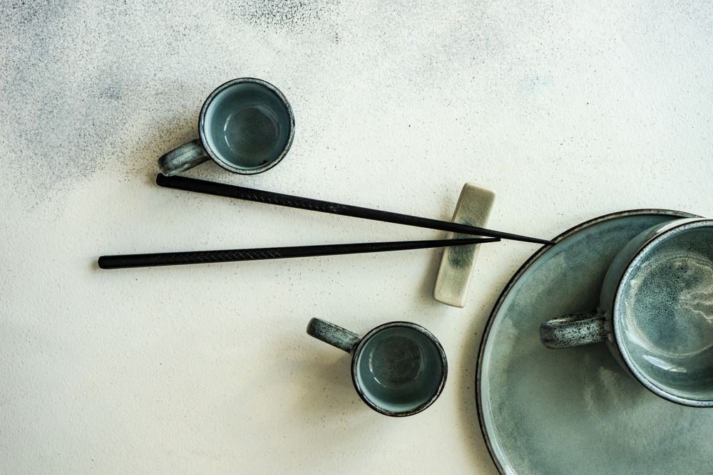 Asian table setting with cups, plate and chopsticks