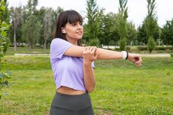 Woman arm stretching exercise outdoors