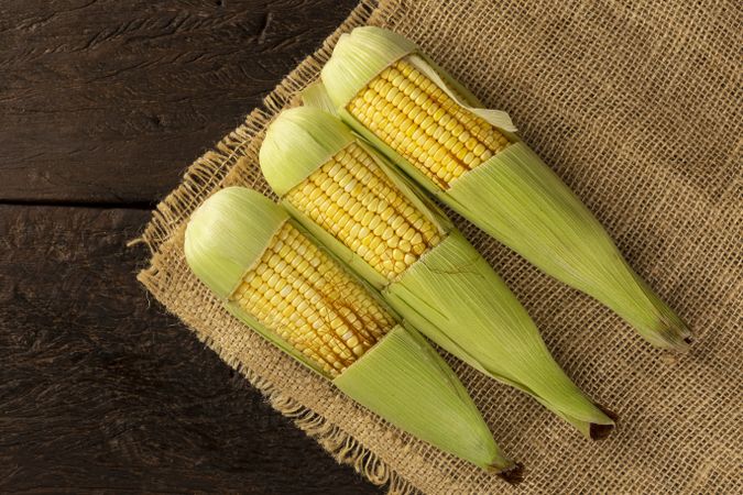 Green corn on the wooden table.