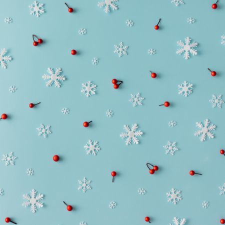 Christmas pattern made of snowflakes and red berries on blue background