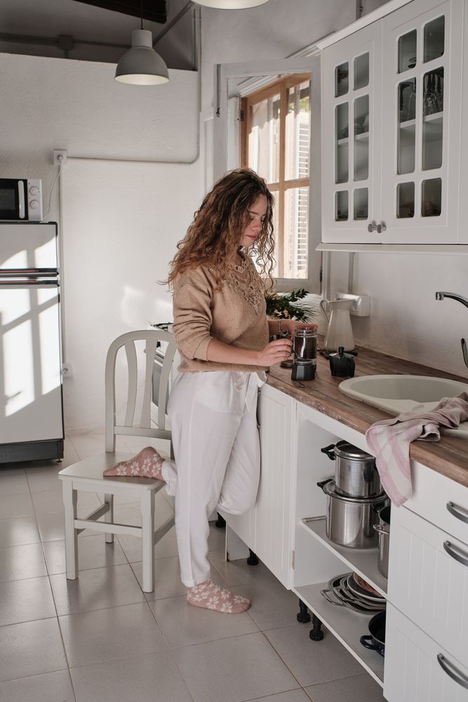 Young woman preparing coffee in kitchen