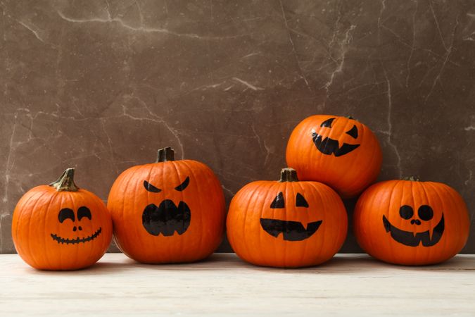 Funny halloween pumpkins against gray background, space for text