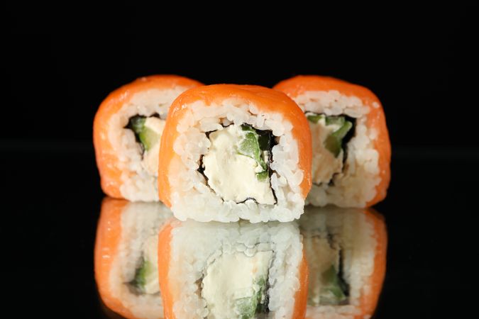 Delicious sushi rolls on dark mirror background. Japanese food