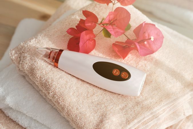 Blackhead remover near flowers on towels