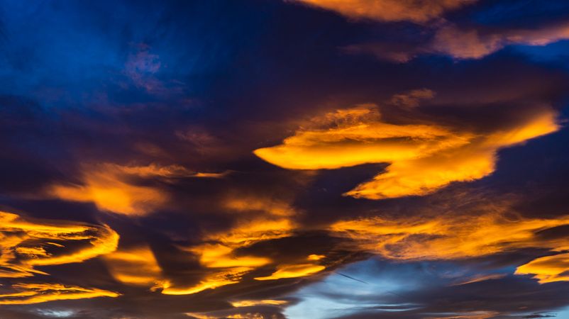 Orange clouds in blue sky background at sunset