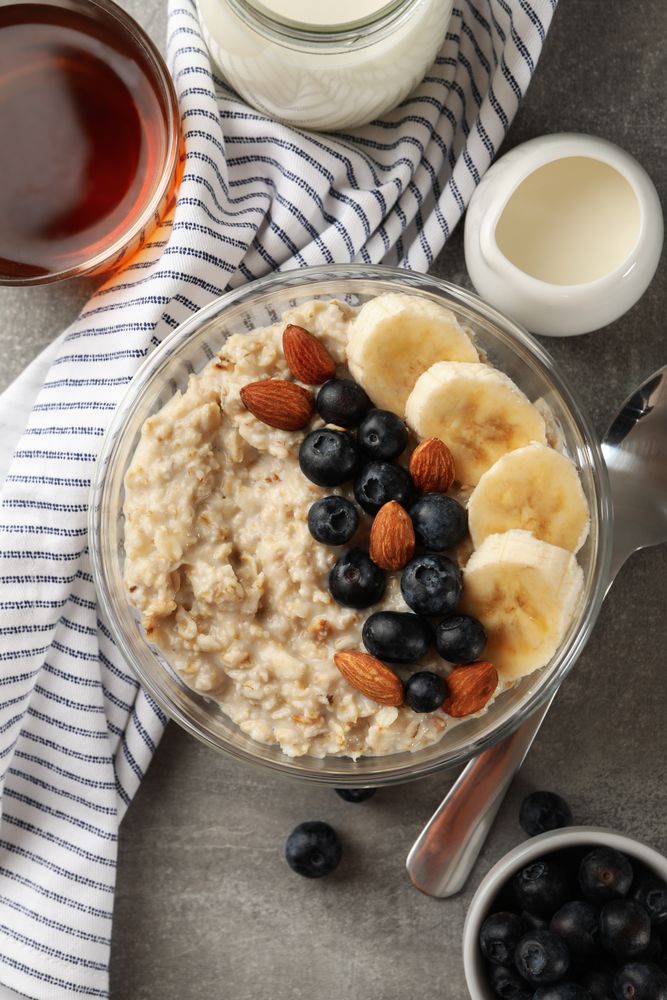 Composition with oatmeal porridge with fruits on gray background