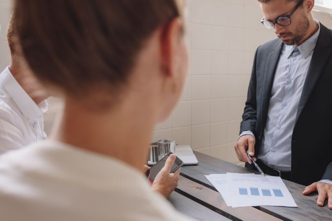 Young male executive explaining a financial plan to coworkers at meeting