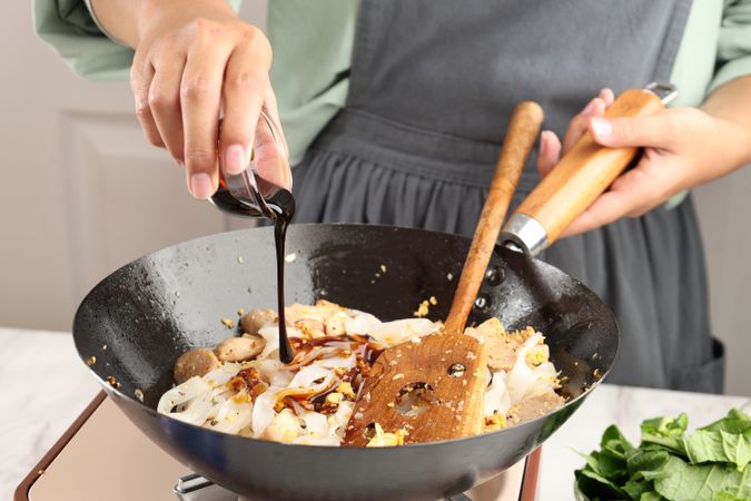 Pour Sweet Soy Sauce Kecap to the Pan with Kwetiau, Chinese Rice Noodles.