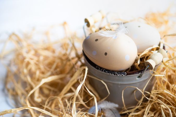 Easter eggs on mini bucket surrounded with hay