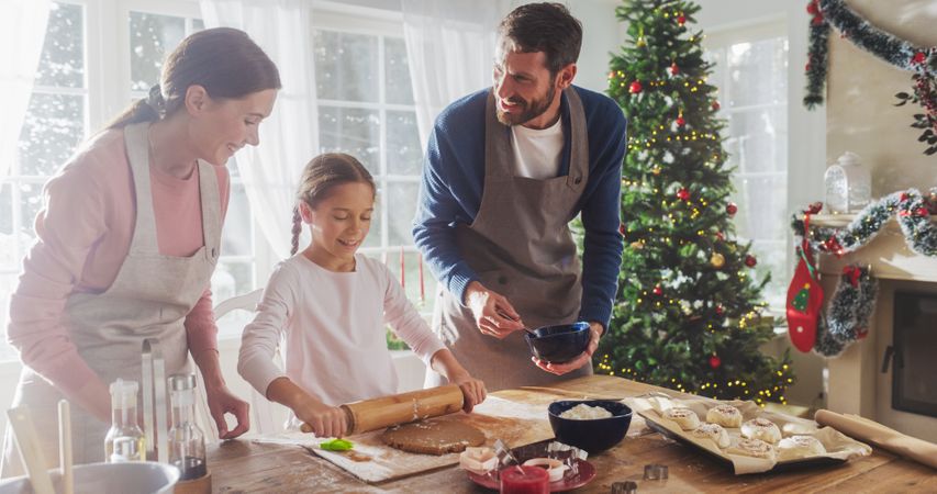 Portrait of Little Cute Girl Learning How to Make Cookies and Celebrating her Achievement with her Parents.