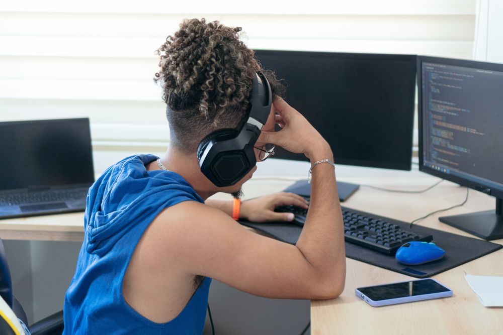 Worried young man working at home with his computer and headset, making a video call