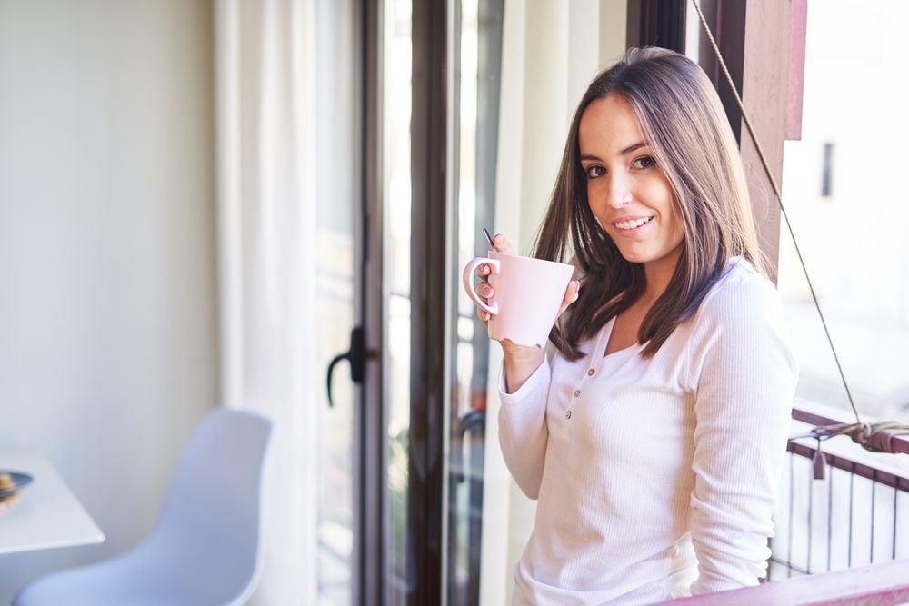 Smiling woman eating at table at home