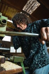 Woodworker sawing planks in workshop