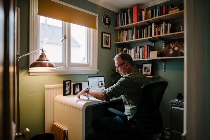 Grey haired man working in cozy home office