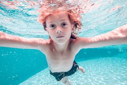 Little boy swimming in clean pool water