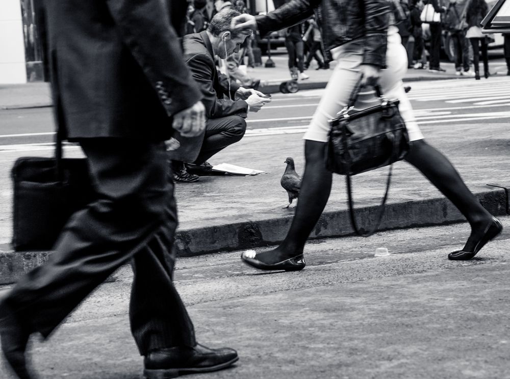 Grayscale photo of people holding suitcases walking on street