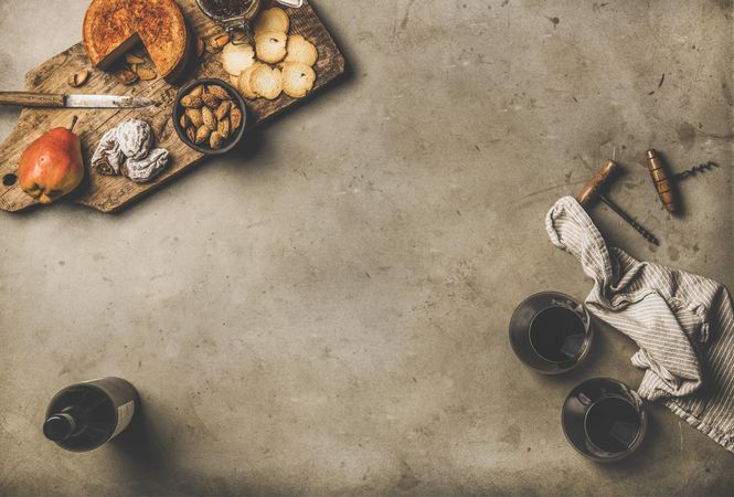 Cheese plate with glasses of red wine, cork crews with copy space in between