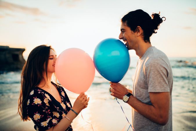 Couple on date standing outdoors at the beach with balloon