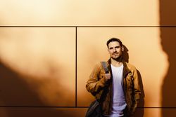 Confident guy leaning on wall