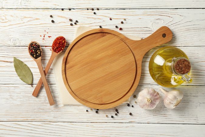 Composition with cutting board and spices on wooden background