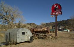 An old camper stands beneath a Frontier Gasoline station sign at the Classical Gas Museum 4AlOR5