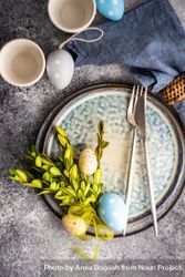 Top view of Easter table setting with branch and decorative grey and blue eggs 0v3RLG
