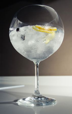 Gin tonic cocktail over a club bar background