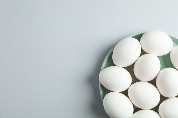chicken eggs in plate on grey background, space for text and top view