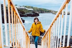 Woman standing on steps near sea