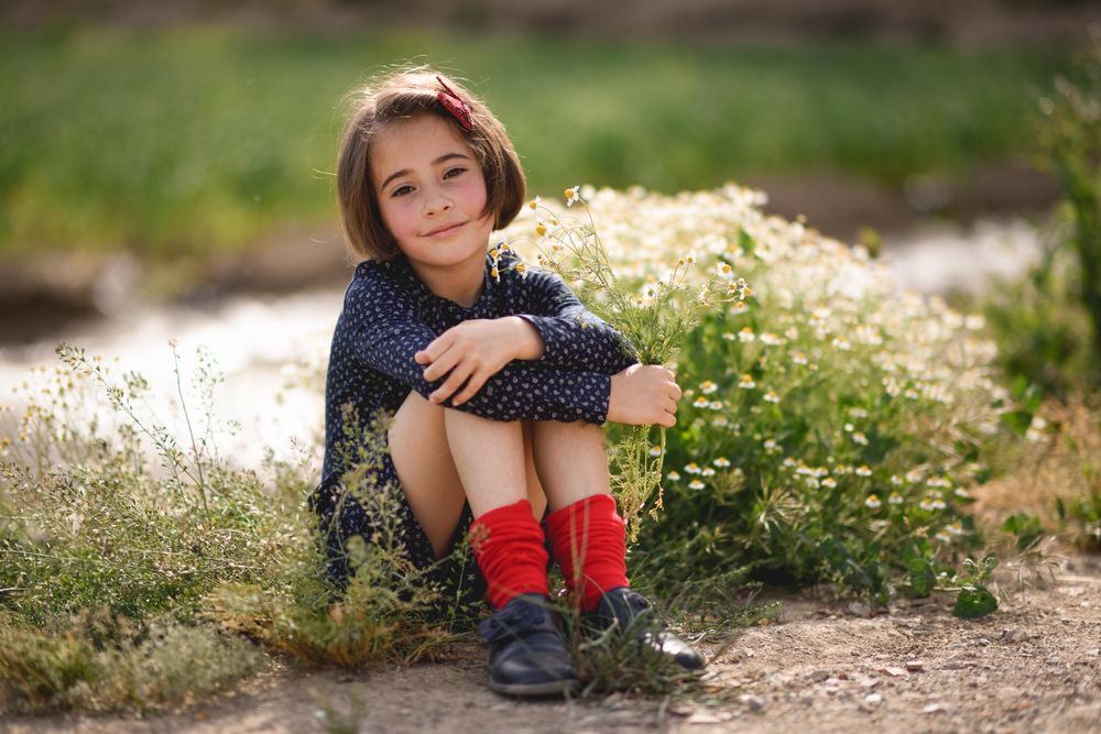 Child sitting with flowers she picked in a beautiful park