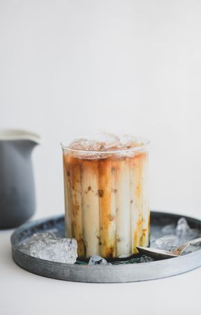 Close up of iced coffee cocktail with milk jug and tray