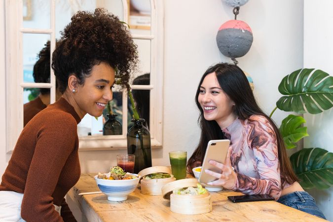 Smiling multiethnic women eating in restaurant